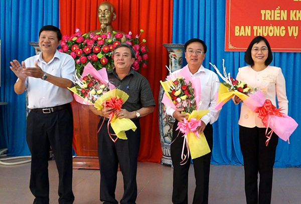 Đồng chí Vũ Thanh Tùng(trái) – Phó bí thư thường trực huyện ủy Cẩm Mỹ tặng hoa chúc mừng các đồng chí Nguyễn Thị Hoàng (phải), Cao Văn Quang (giữa), Trần Văn Chiến nhận nhiệm vụ mới.