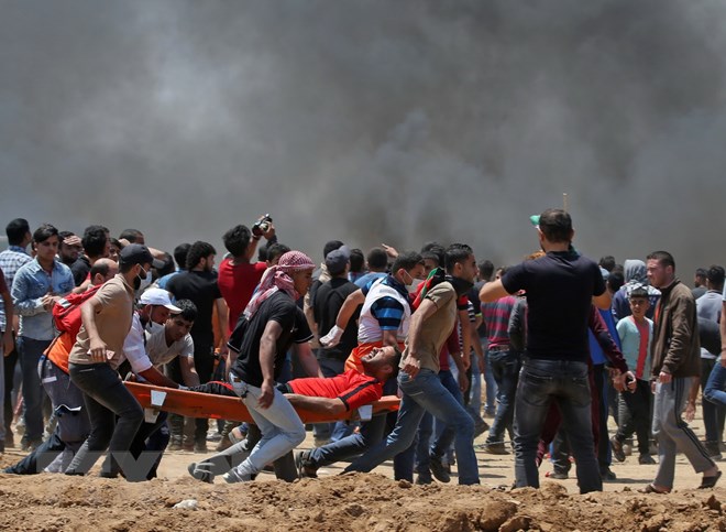 Chuyển người biểu tình Palestine bị thương sau các cuộc đụng độ với binh sỹ Israel tại khu vực biên giới Dải Gaza với Israel ngày 14/5. (Nguồn: AFP/TTXVN)