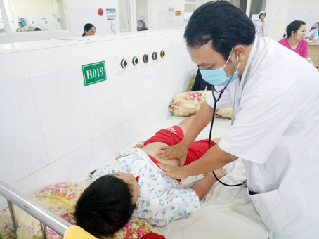 Bác sĩ Bệnh viện nhi đồng Đồng Nai đang thăm khám cho bé N.M.H. bị bệnh sốt xuất huyết.  Ảnh: N.SƠN