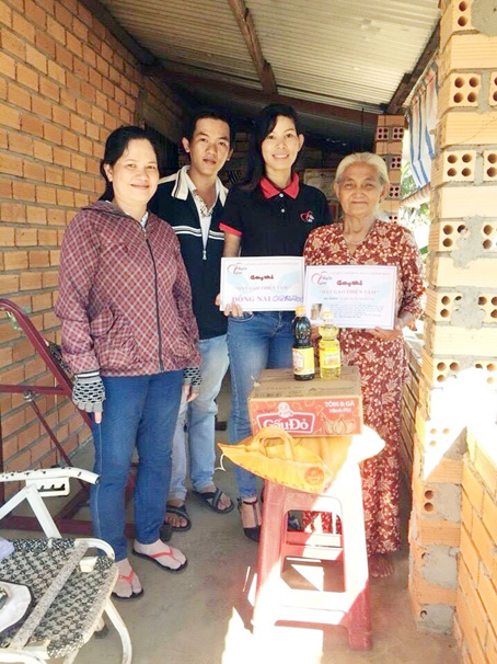 Cô giáo Nguyễn Thị Thanh Tiên (thứ 2 từ phải qua) đem gạo đến tặng một hộ nghèo ở huyện Tân Phú.