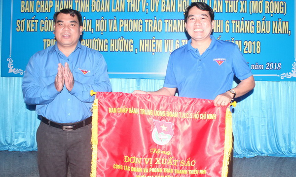 Bí thư Tỉnh đoàn Nguyễn Cao Cường (bìa trái), Bí thư Tỉnh đoàn trao cờ thu đua đơn vị xuất sắc năm 2017 cho đại diện Huyện đoàn Nhơn Trạch 