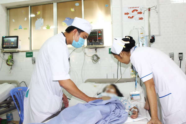 Bác sĩ, điều dưỡng Khoa Hồi sức tích cực - chống độc Bệnh viện nhi đồng Đồng Nai đang thăm khám, chăm sóc bệnh nhi. Ảnh: H.DUNG