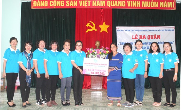 Bà Bùi Thị Hạnh (thứ 6 từ trái sang) trao bảng tượng trưng một mái ấm tình thương cho hội viên phụ nữ xã Đăk Nhoong 