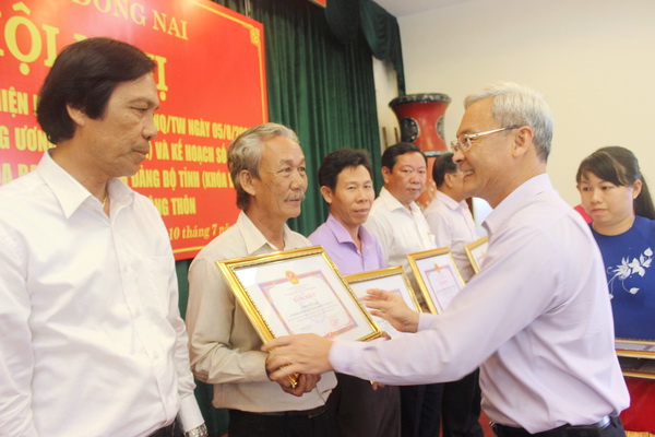Bí thư Tỉnh ủy Nguyễn Phú Cường trao bằng khen cho những tập thể hoàn thành xuất sắc nhiệm vụ trong thực hiện nghị quyết về tam nông.