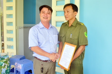 Cựu chiến binh Nguyễn Trường Giang (trái) trao quyết định tặng nhà đồng đội cho cựu chiến binh Nguyễn Công Được (xã Long Giao, huyện Cẩm Mỹ).