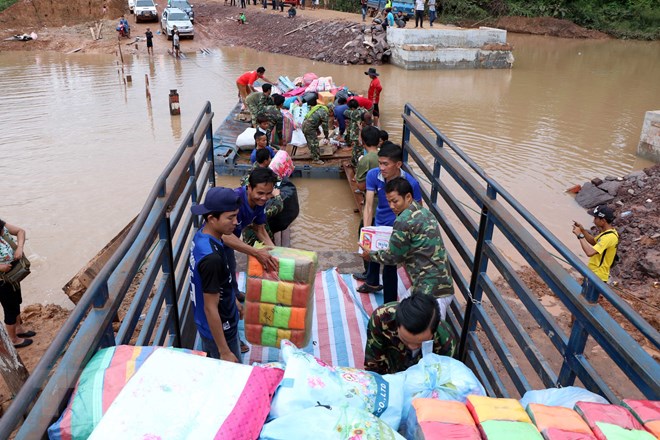 Vận chuyển hàng hóa cứu trợ cho người dân bị ảnh hưởng trong sự cố vỡ đập thủy điện. (Ảnh: Quang Thái/TTXVN)