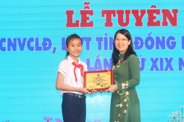 Chủ tịch Liên đoàn Lao động tỉnh Nguyễn Thị Như Ý trao biểu trưng khen thưởng các em học sinh cấp tiểu học