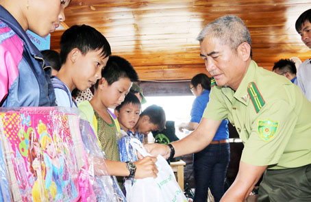 Đại diện Khu Bảo tồn thiên nhiên - văn hóa Đồng Nai trao quà cho trẻ em ở làng bè La Ngà, xã La Ngà, huyện Định Quán. Ảnh: V.TUYÊN