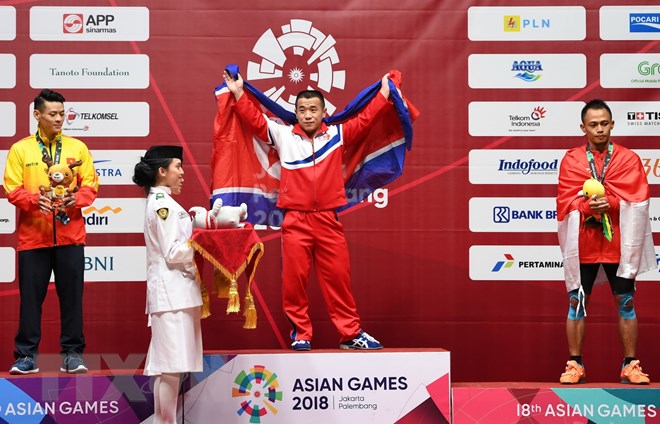 Vận động viên Việt Nam Thạch Kim Tuấn (trái) giành huy chương bạc, Om Yun Chol (giữa) của Triều Tiên giành huy chương vàng và Surahmat Bin Suwoto Wijoyo của Indonesia giành huy chương đồng nội dung cử tạ hạng 56kg. (Nguồn: AFP/ TTXVN