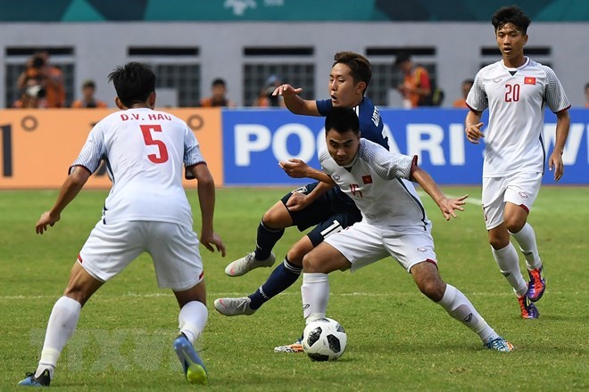 Pha tranh bóng quyết liệt giữa cầu thủ Phạm Đức Huy (thứ 2, phải) của Olympic Việt Nam và Kouta Wanabe (giữa, phía sau) của Olympic Nhật Bản trong trận đấu ở bảng D, ASIAD 2018 ở Cikarang, Indonesia ngày 19-8. (Ảnh: AFP/TTXVN)