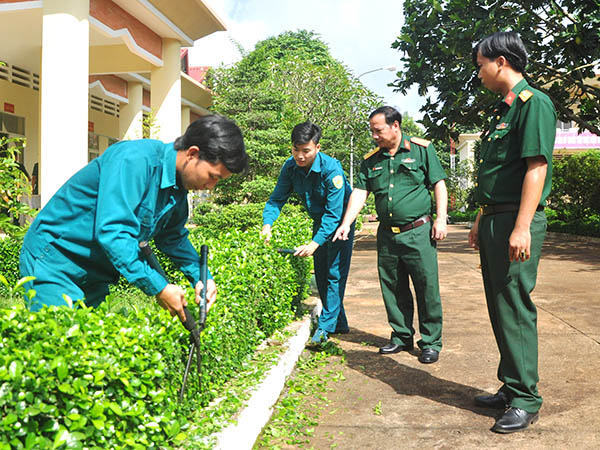 Thượng tá Nguyễn Tường Linh, Chỉ huy trưởng Ban CHQS huyện Cẩm Mỹ (thứ 2 từ phải qua) kiểm tra quá trình chăm sóc cây cảnh tại đơn vị. Ảnh: M.Thành