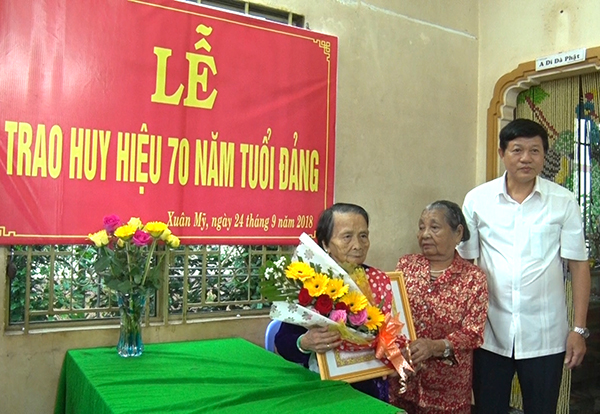 Đồng chí Vũ Thanh Tùng- Phó bí thư thường trực huyện ủy Cẩm Mỹ đã trực tiếp tặng hoa và trao huy hiệu 70 năm tuổi Đảng cho đồng chí Trần Thị An