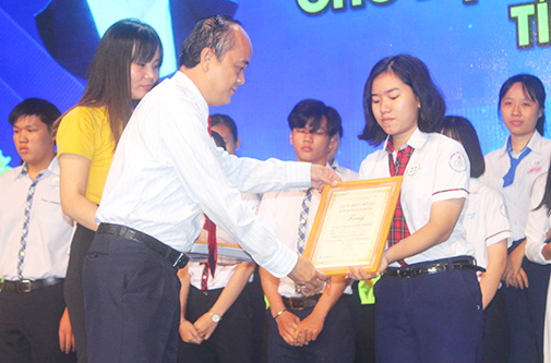 Phó giám đốc Sở Thông tin - truyền thông Võ Hoàng Khai trao học bổng cho học sinh.