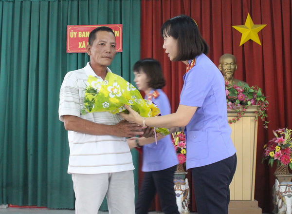 Bà Phạm Thị Mến, Phó Viện trưởng VKSND huyện Vĩnh Cửu trao hoa xin lỗi ông Bùi Xuân Quang