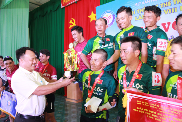 Giám đốc Trung tâm Huấn luyện và thi đấu TDTT tỉnh Bùi Anh Vũ trao cúp vô địch đồng đội cho đội huyện Xuân Lộc