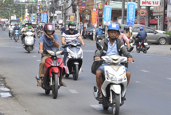 Nhiều người vừa chạy xe máy vừa chăm chú xem điện thoại dẫn đến thiếu chú ý quan sát rất nguy hiểm. Ảnh chụp trên đường Phạm Văn Thuận (TP.Biên Hòa) vào tháng 8-2018.