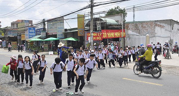 Sau giờ tan trường, học sinh Trường tiểu học Trảng Dài (TP.Biên Hòa) di chuyển sang đường chưa đảm bảo an toàn.
