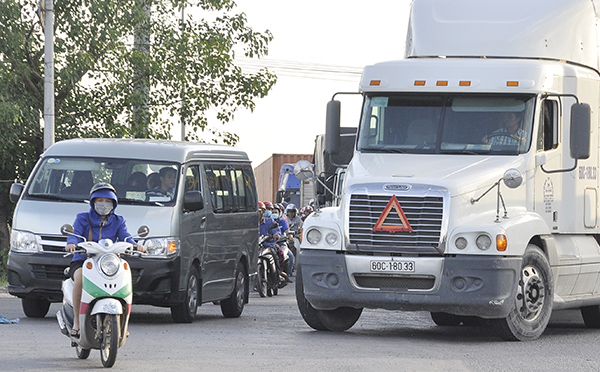 Việc lưu thông hỗn hợp giữa xe máy với các phương tiện khác gây xung đột giao thông. Trong ảnh: Xe máy cắt ngang xe ô tô tại  nút giao  khu vực cầu Sập (TP.Biên Hòa). 