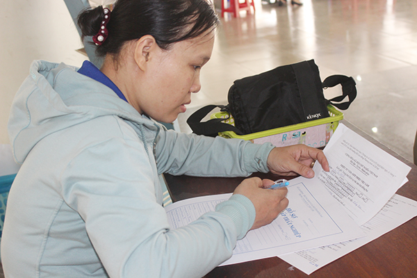 Một nữ lao động lớn tuổi đã nghỉ việc đang làm hồ sơ để hưởng chế độ bảo hiểm thất nghiệp tại Trung tâm dịch vụ việc làm Đồng Nai.