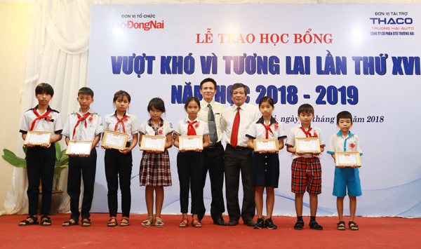 Tổng biên tập Báo Đồng Nai Nguyễn Tôn Hoàn và ông Đoàn Công Thành, đại diện Công ty oto Trường Hải trao học bổng cho các em học sinh.