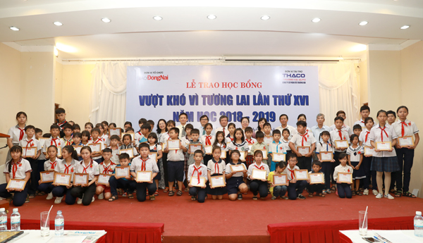 Các đại biểu, lãnh đạo báo Đồng Nai, đại diện nhà tài trợ chụp hình lưu niệm với các em học sinh được nhận học bổng