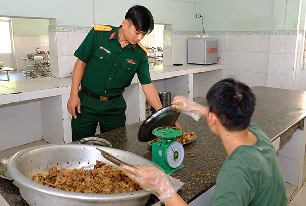 Trung úy Hán Văn Nam, nhân viên quản lý bếp ăn Tiểu đoàn 9 (Trung đoàn 3, Sư đoàn 9) kiểm tra việc định lượng thực phẩm cho bữa ăn quân đội.