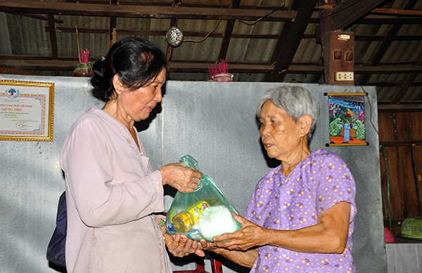 Bà Nguyễn Thị Thành (trái) trao quà cho bà Nguyễn Thị Nhâm (ấp 2, xã Sông Trầu) có hoàn cảnh khó khăn.
