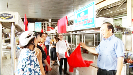 Đại diện Sở Công thương gắn biển các điểm kinh doanh thực phẩm an toàn tại chợ Dầu Giây (huyện ThốngNhất).