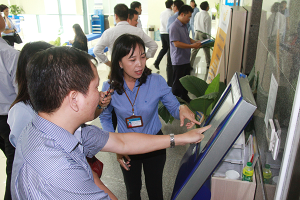 Bà Nguyễn Thị Thanh Thảo, Giám đốc Trung tâm hành chính công tỉnh Đồng Nai giới thiệu quy trình lấy số thứ tự khi đến giao dịch tại đơn vị.