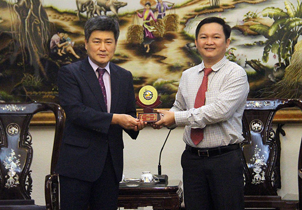 Phó giám đốc Sở Kế hoạch - đầu tư Nguyễn Hữu Nguyên tặng quà lưu niệm cho ông Jang Ho Young, đại diện đoàn công tác của TP.Cheonan (Hàn Quốc). 