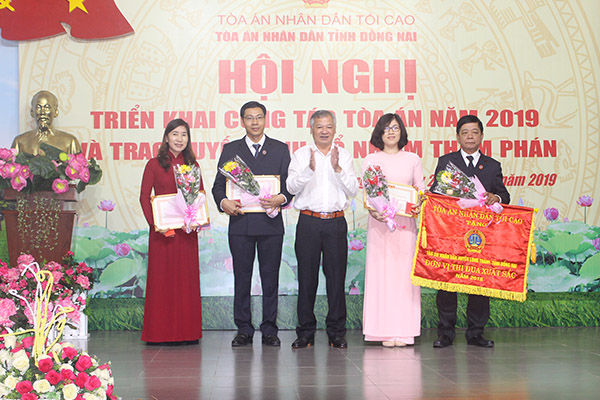 Đồng chí Hồ Văn Năm, Trưởng đoàn đại biểu Quốc hội tỉnh, Trưởng ban Nội chính Tỉnh ủy (giữa) trao Cờ thi đua xuất sắc cho Tòa án nhân dân huyện Long Thành và bằng khen cho các cá nhân có thành tích xuất sắc