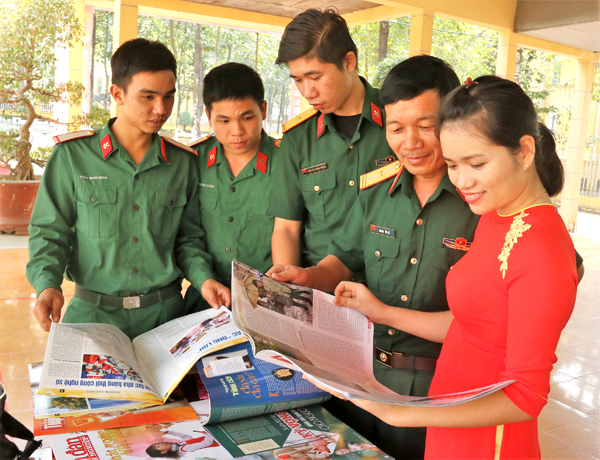 Cán bộ, chiến sĩ Lữ đoàn Công binh 25 (TP.Biên Hòa) và nhân viên Thư viện tỉnh đọc sách báo xuân tại Hội báo Xuân được 2 đơn vị tổ chức tại Lữ đoàn công binh 25