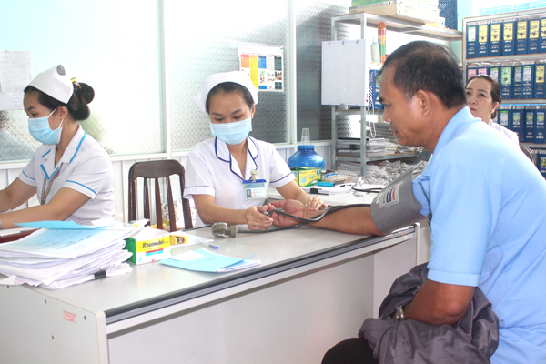 Nhân viên y tế Trung tâm y tế huyện Nhơn Trạch đo huyết áp cho người dân đến khám bệnh tại trung tâm  Ảnh: A.YÊN
