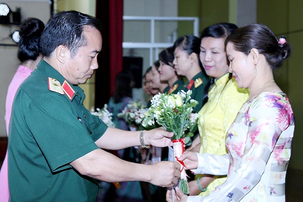 Thiếu tướng Nguyễn Xuân Sơn, Chính ủy Quân đoàn tặng quà và hoa cho các nữ đại biểu. Ảnh: Lê Cầu.