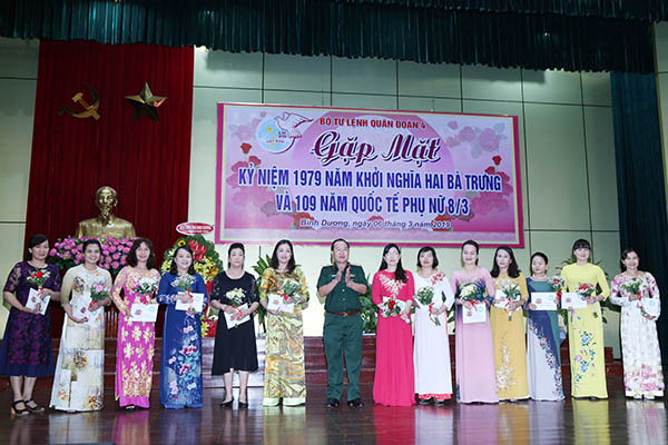 Thiếu tướng Phạm Xuân Thuyết, Tư lệnh Quân đoàn tặng quà và hoa cho đại biểu phụ nữ là các phu nhân của sĩ quan. Ảnh: Lê Cầu.