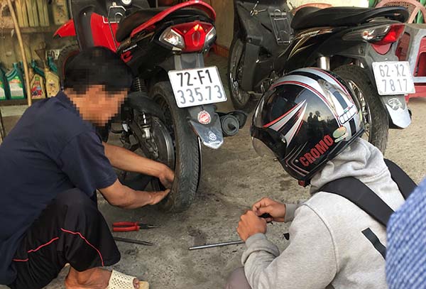 Người đi đường bị thủng bánh xe và đang vá tại 1 tiệm sửa xe địa bàn xã Tam Phước (TP.Biên Hòa)