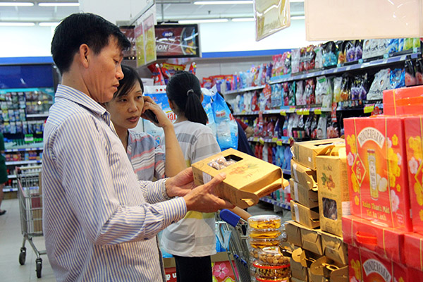 Người tiêu dùng tham khảo, chọn mua các sản phẩm hạt, quả khô đóng hộp ở một siêu thị tại TP.Biên Hòa. Ảnh: H.Quân