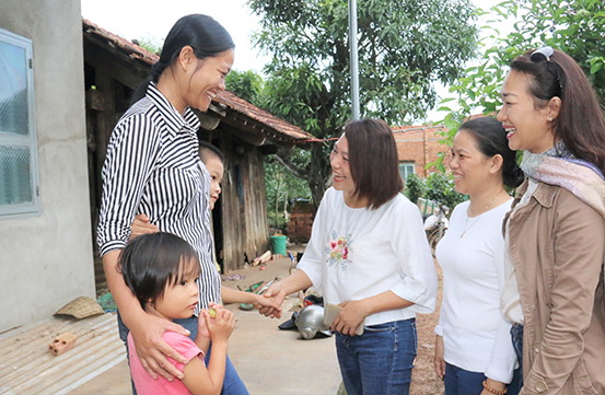 Mẹ con bà Trần Thị Dung (ngụ xã Sông Ray) vui mừng bên căn nhà mới cùng những người giúp bà kinh phí xây nhà