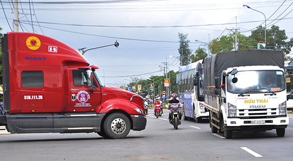 Xe máy chạy len lỏi giữa những xe lớn lưu thông trên quốc lộ 1 (đoạn qua huyện Xuân Lộc) nên nguy cơ tai nạn giao thông dễ xảy ra
