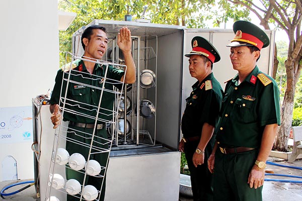 Thiếu tá Phùng Việt Cường (trái), cán bộ Ban Chính trị, Trung đoàn 250 (Sư đoàn 309) thuyết minh cho lãnh đạo Quân đoàn 4 và Sư đoàn 309 cách hoạt động của máy rửa chén