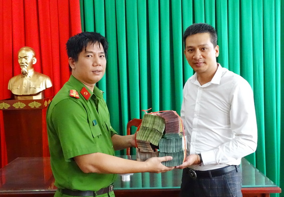 Đại diện CQ CSĐT Công an tỉnh Đồng Nai trao trả số tiền hơn 1,7 triệu đồng cho trạm thu phí.