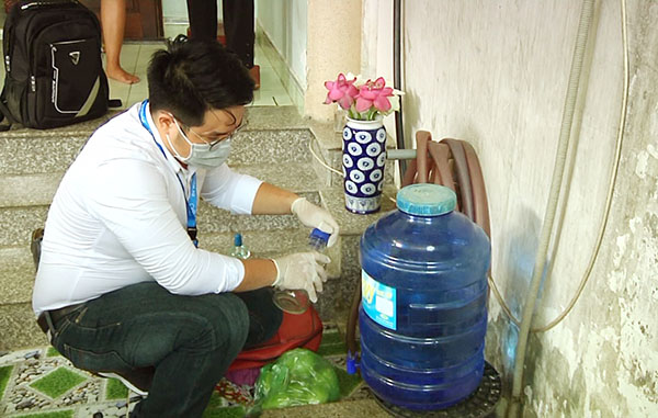 Lực lượng chức năng lấy mẫu nước dùng để chữa bệnh tại cơ sở ông Trịnh Xuân Vượng để kiểm tra, xét nghiệm