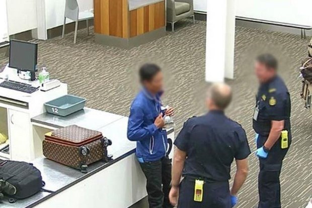 Lực lượng chức năng Australia tiếp cận người đàn ông Việt Nam mang theo cá rồng khi xuất hiện tại sân bay Adelaide. (Nguồn: ABF)