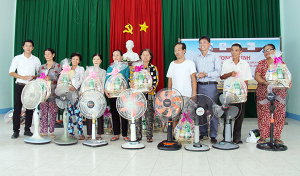 Đại diện chính quyền xã An Phước (bìa trái) và đơn vị tài trợ tặng quà các gia đình chính sách.
