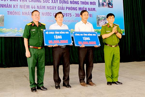 Lãnh đạo Bộ Chỉ huy quân sự tỉnh và Công an tỉnh trao số tiền tượng trưng cho lãnh đạo xã Long An. 