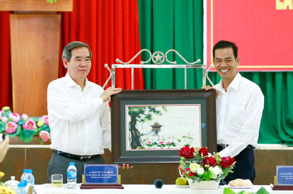 Đồng chí Nguyễn Văn Bình (bìa trái) tặng quà cho Bí thư Huyện ủy Vĩnh Cửu Trần Trung Nhân. Ảnh: Huy Anh