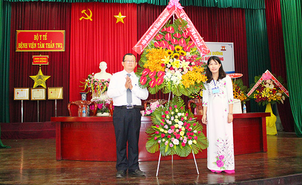 ThS.Huỳnh Tú Anh, Chủ tịch Hội Điều dưỡng tỉnh (trái) tặng lẵng hoa chúc mừng Chi hội Điều dưỡng Bệnh viện Tâm thần Trung ương 2 tại buổi lễ.