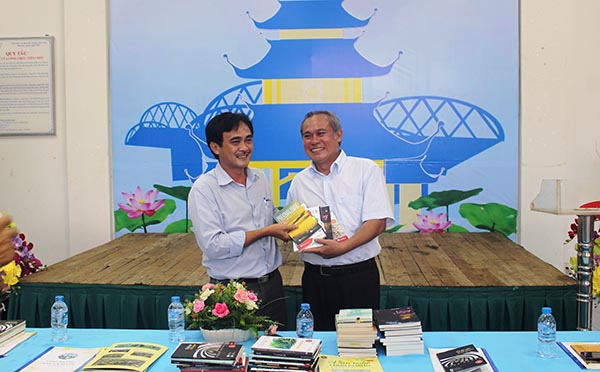 Nhà thơ Phan Hoàng (trái) tặng sách trong một buổi giao lưu tại TX.Long Khánh