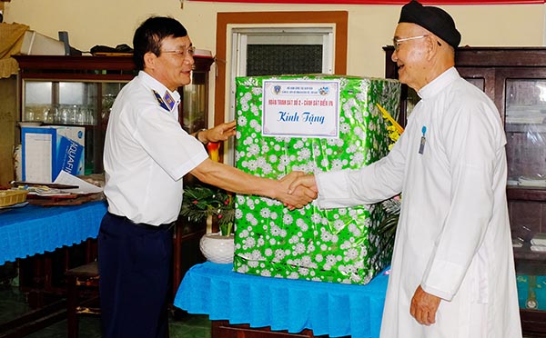 Thiếu tướng Doãn Bảo Quyết, Phó chính ủy Cảnh sát biển Việt Nam (trái) thăm, tặng quà cho đại diện Thánh thất Cao Đài Đại Phước. Ảnh: M.Thành