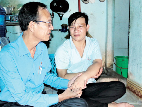 Anh Đới Sỹ Hòa (bìa phải - một nạn nhân bị tai nạn lao động, quê huyện Tân Phú), công nhân Công ty TNHH một thành viên cao su Kenda Việt Nam (Khu công nghiệp Hố Nai, huyện Trảng Bom) như muốn khóc khi được hỏi về cánh tay không thể điều khiển được với tỷ lệ thương tật 65%. ảnh: V.Truyên